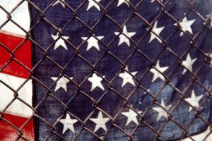 American Flag Behind Chain-Link Fence