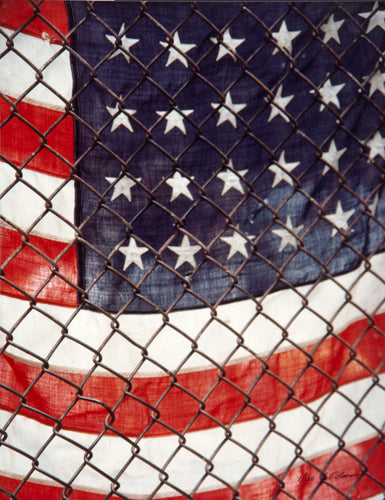 American Flag Behind Chain-Link Fence